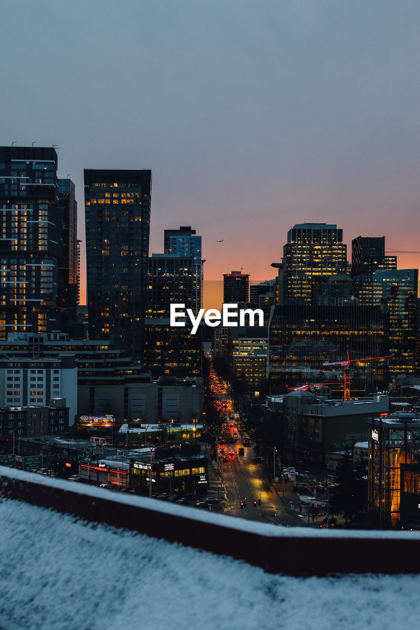 Winter sunset in downtown seattle as seen from snow covered capitol hill rooftop