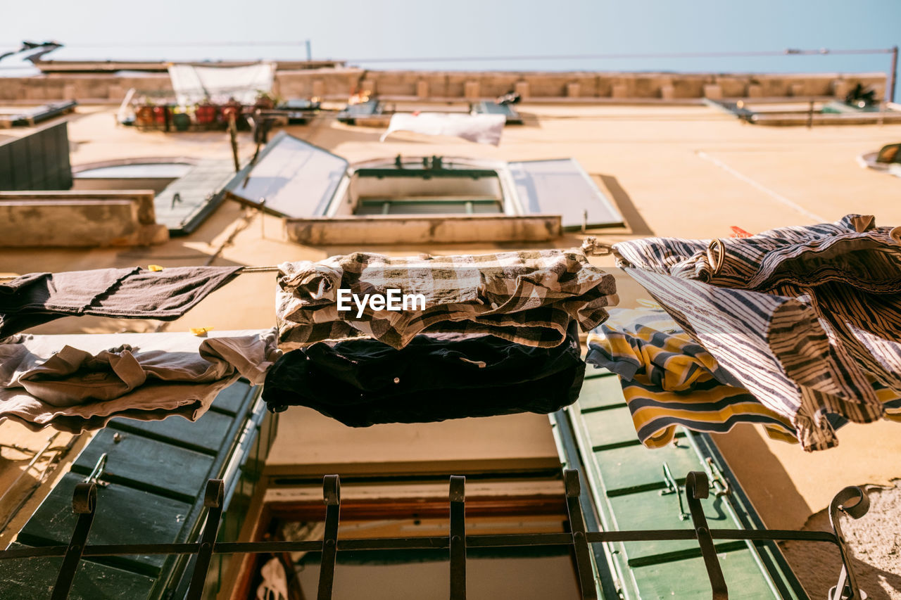 Low angle view of clothes hanging on clothesline by building in city