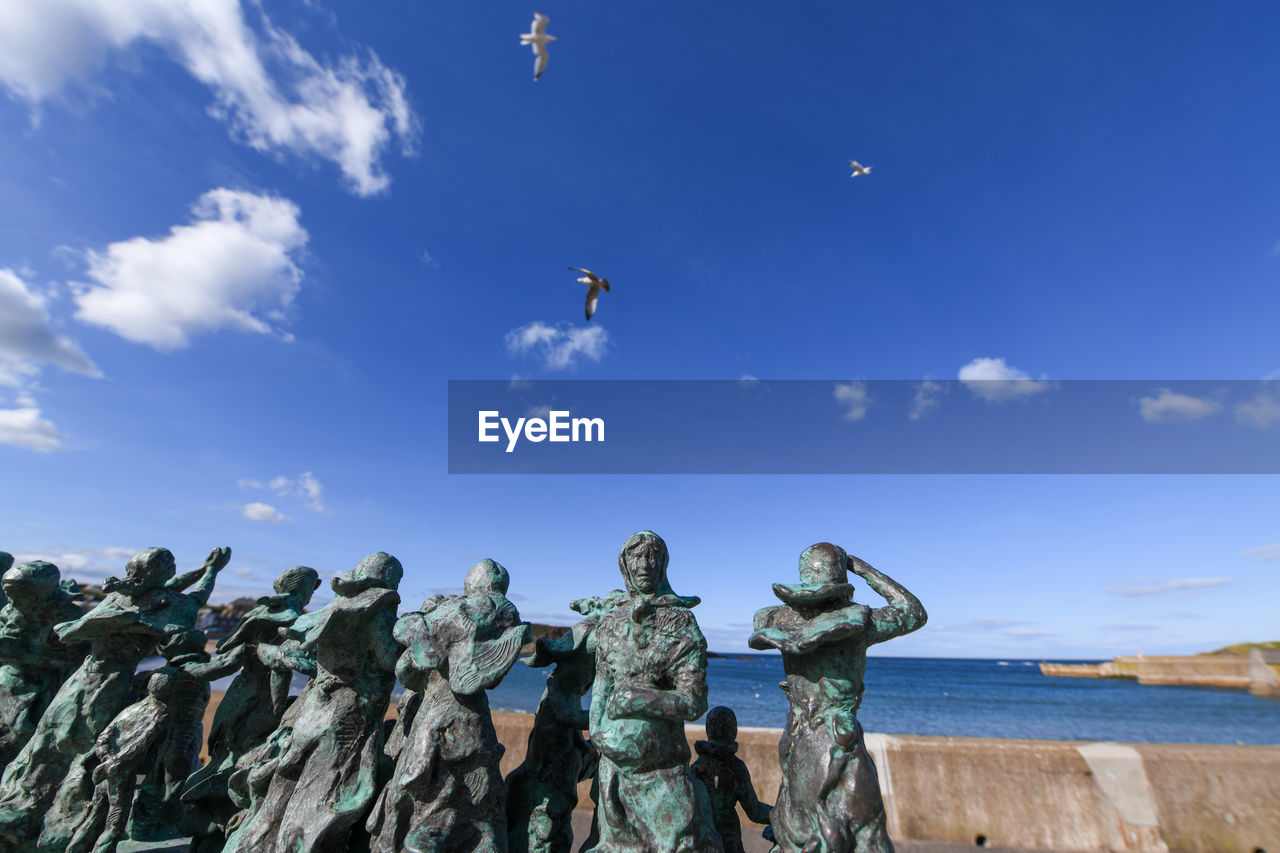 LOW ANGLE VIEW OF SCULPTURE AGAINST BLUE SKY