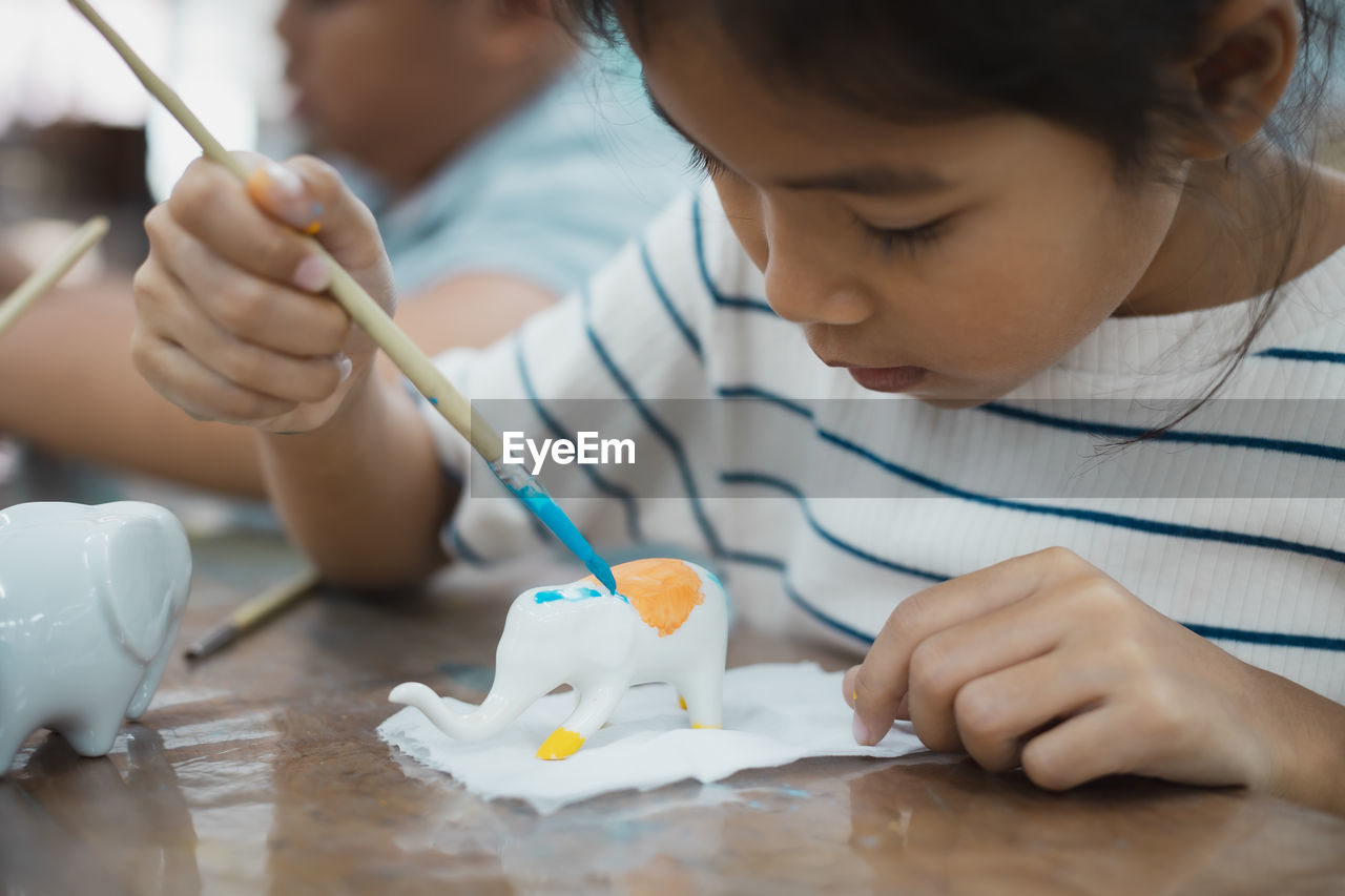 Cute girl making decoration on table