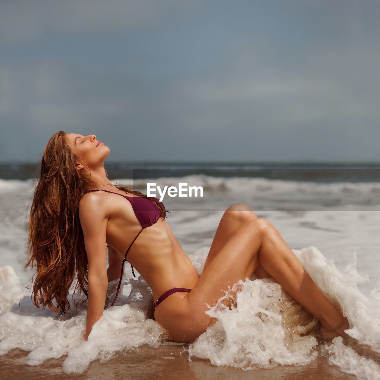 rear view of woman swimming in sea against sky