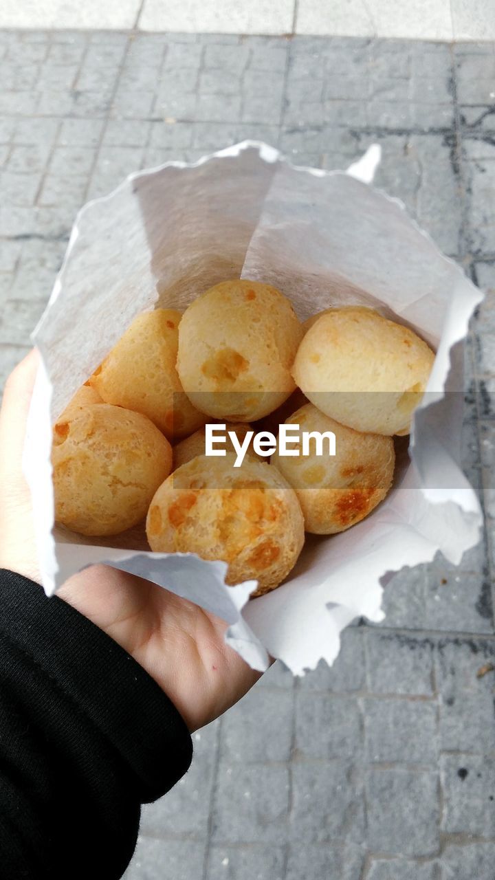 HIGH ANGLE VIEW OF HAND HOLDING FOOD