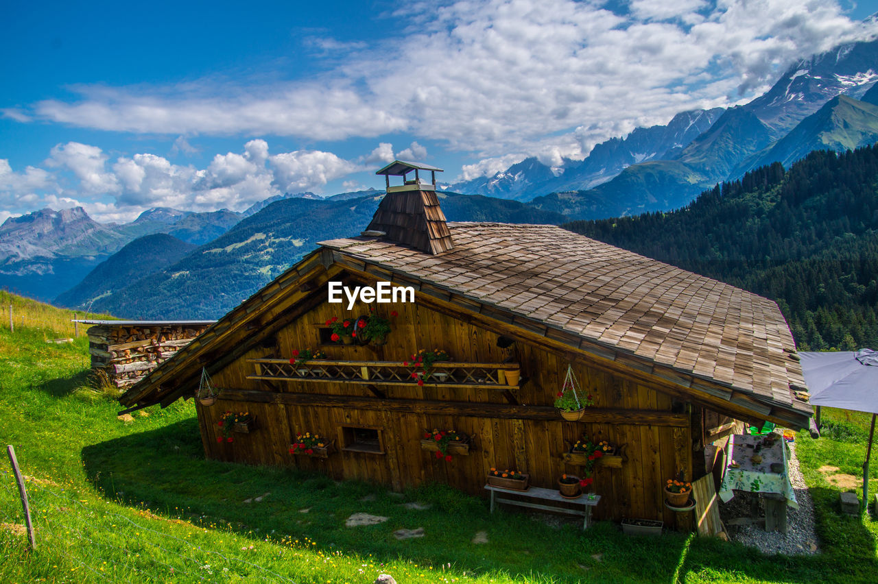 BUILT STRUCTURE ON FIELD AGAINST MOUNTAIN RANGE