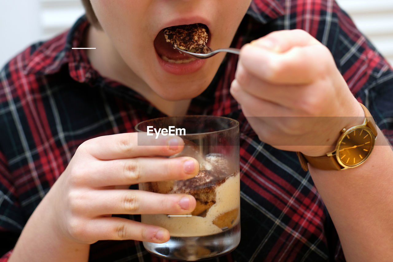 MIDSECTION OF WOMAN DRINKING GLASS WITH DRINK