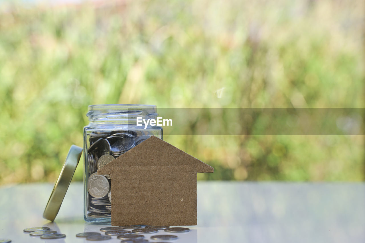 CLOSE-UP OF JAR ON TABLE AGAINST YELLOW BACKGROUND