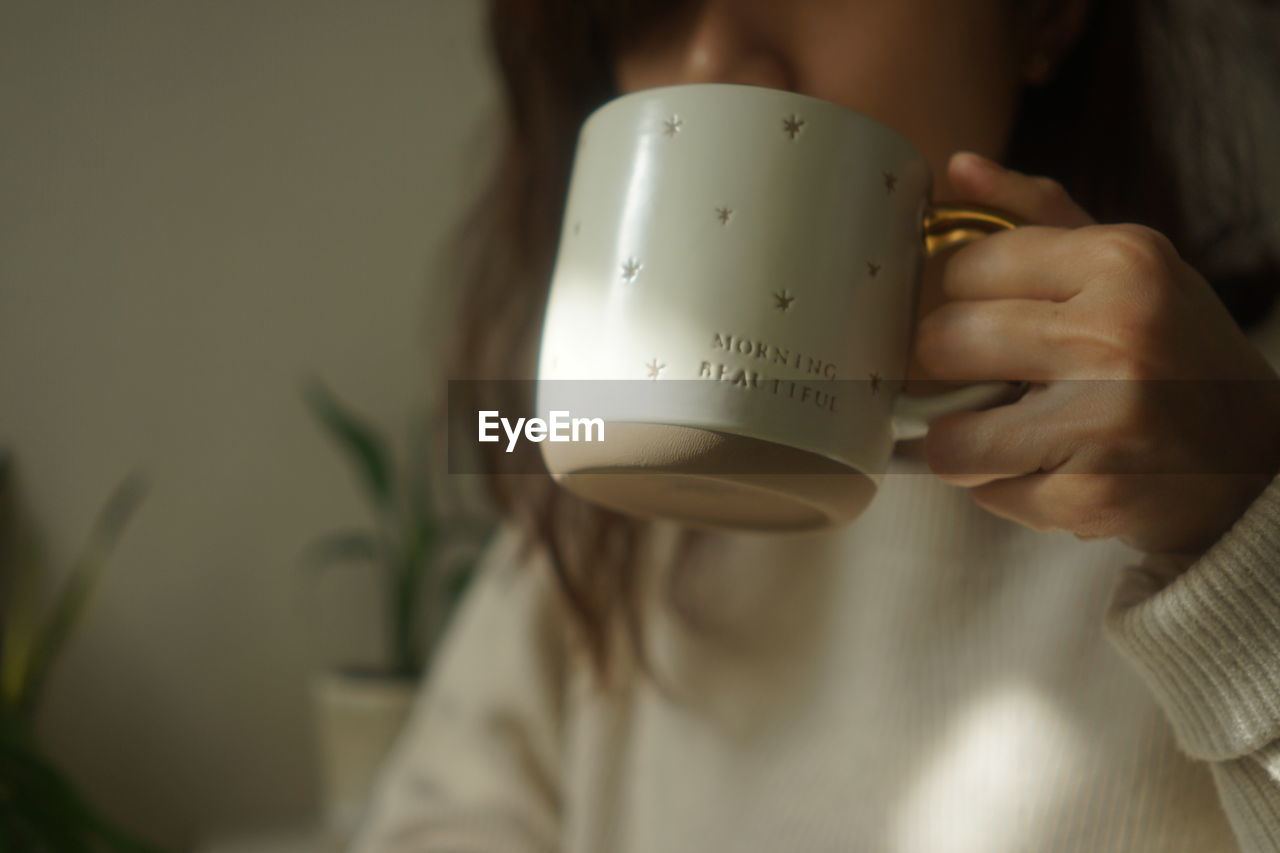 Japanese woman holding a cup of coffee in the morning