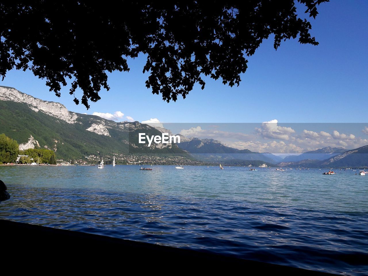 Scenic view of sea and mountains against blue sky