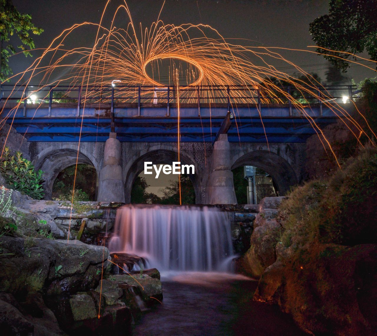 Burning a wirewool in the bridge over river at night