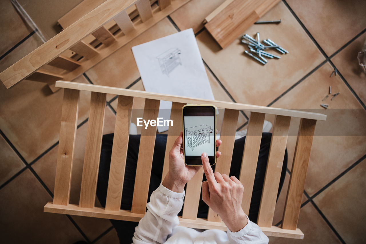 HIGH ANGLE VIEW OF WOMAN USING SMART PHONE