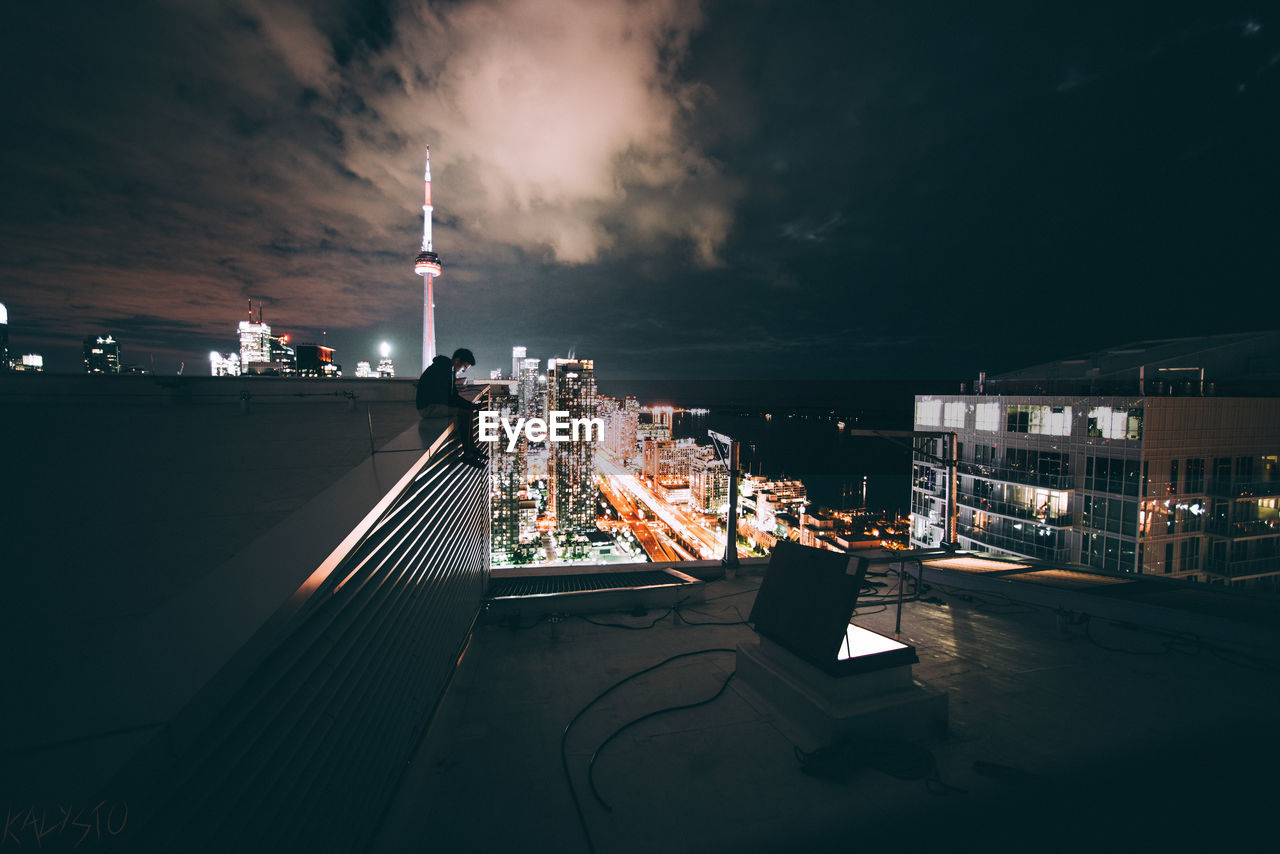 VIEW OF ILLUMINATED CITY AGAINST SKY AT NIGHT