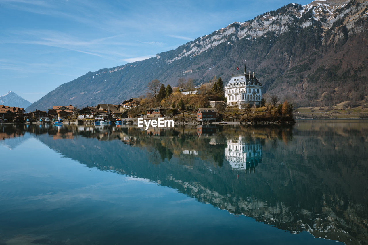 BUILDINGS BY LAKE AGAINST SKY