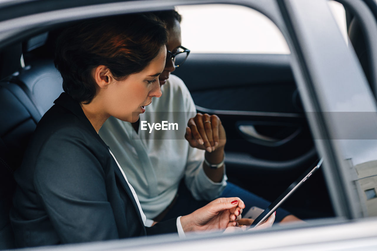 Businesswomen discussing while sitting in car