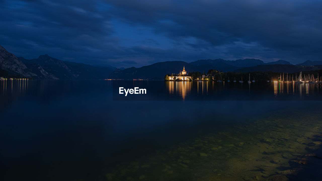 Scenic view of lake against sky at night