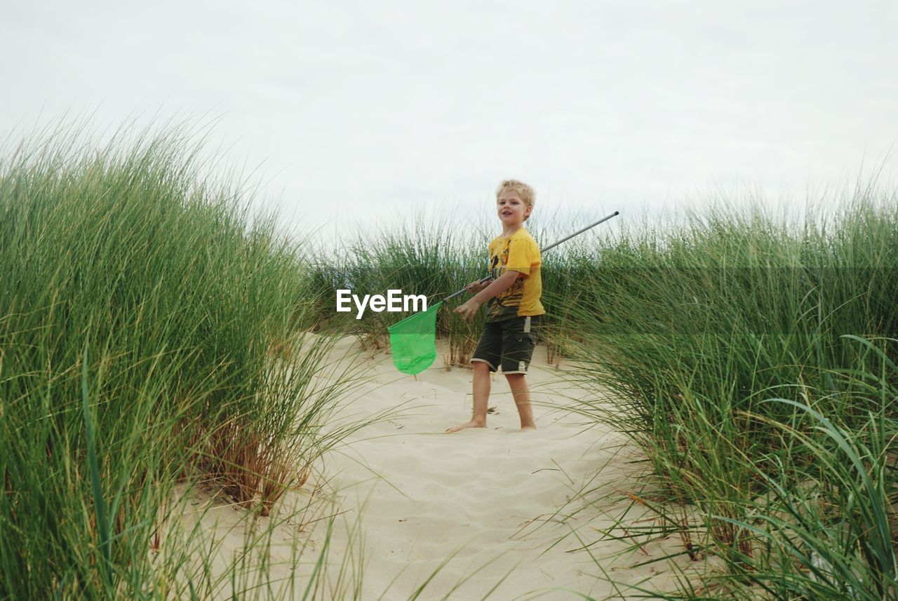 FULL LENGTH OF A BOY STANDING ON GRASS