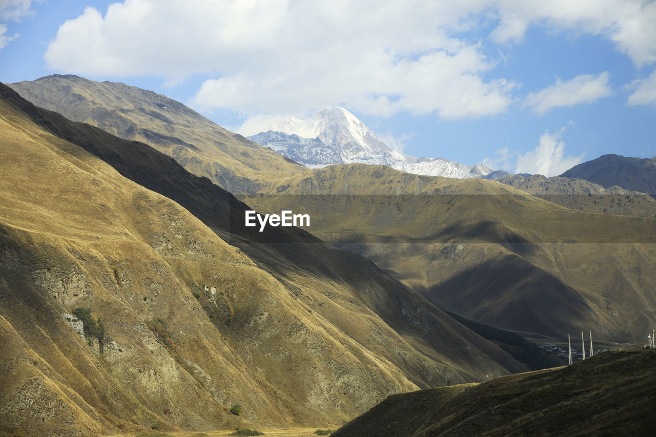 Scenic view of mountains against cloudy sky