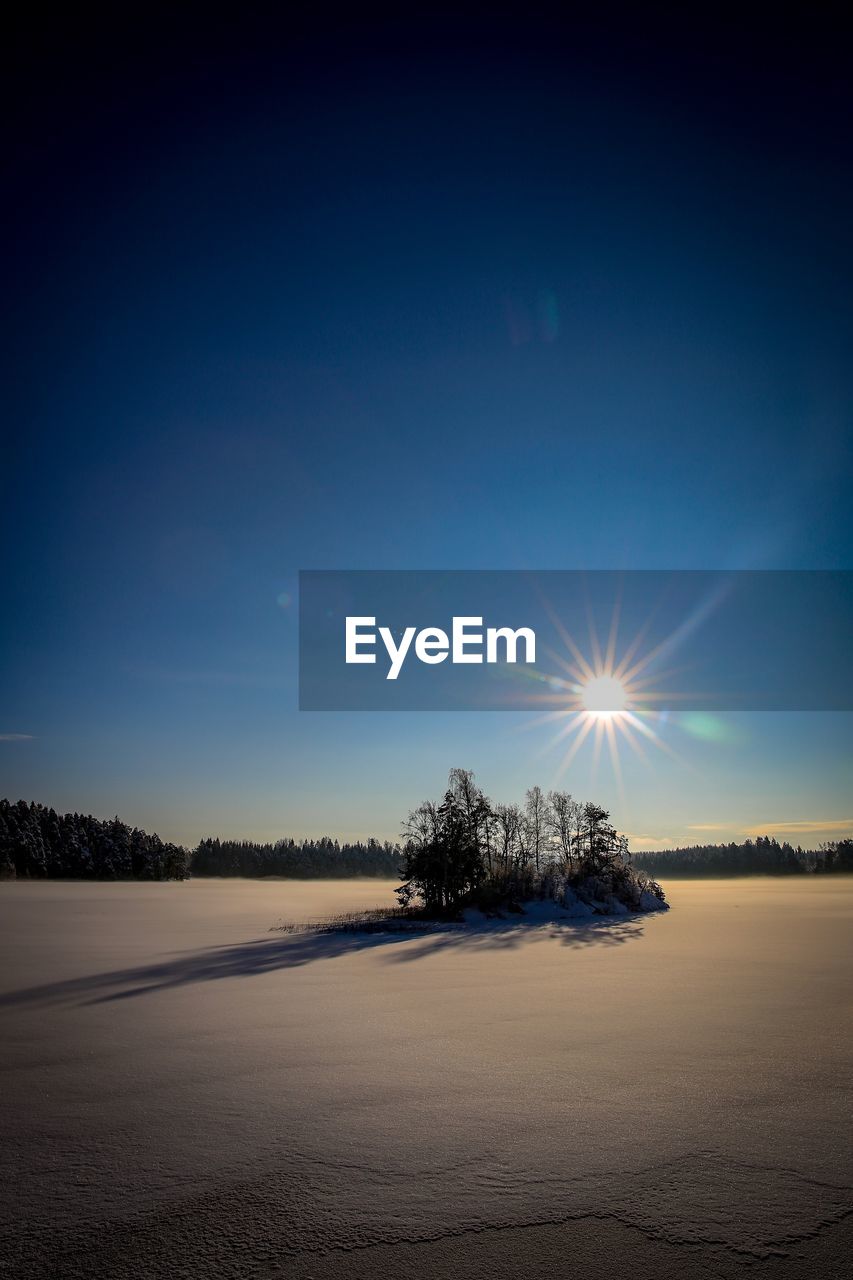 Scenic view of landscape against blue sky during winter