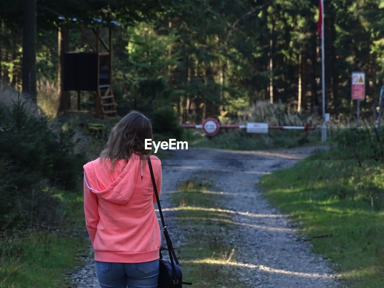 Rear view of woman walking on footpath