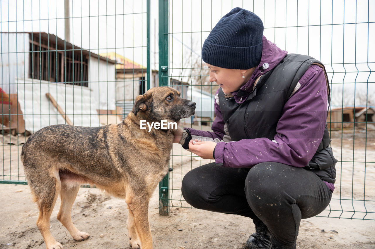 Girl volunteer in the nursery for dogs. shelter for stray dogs.