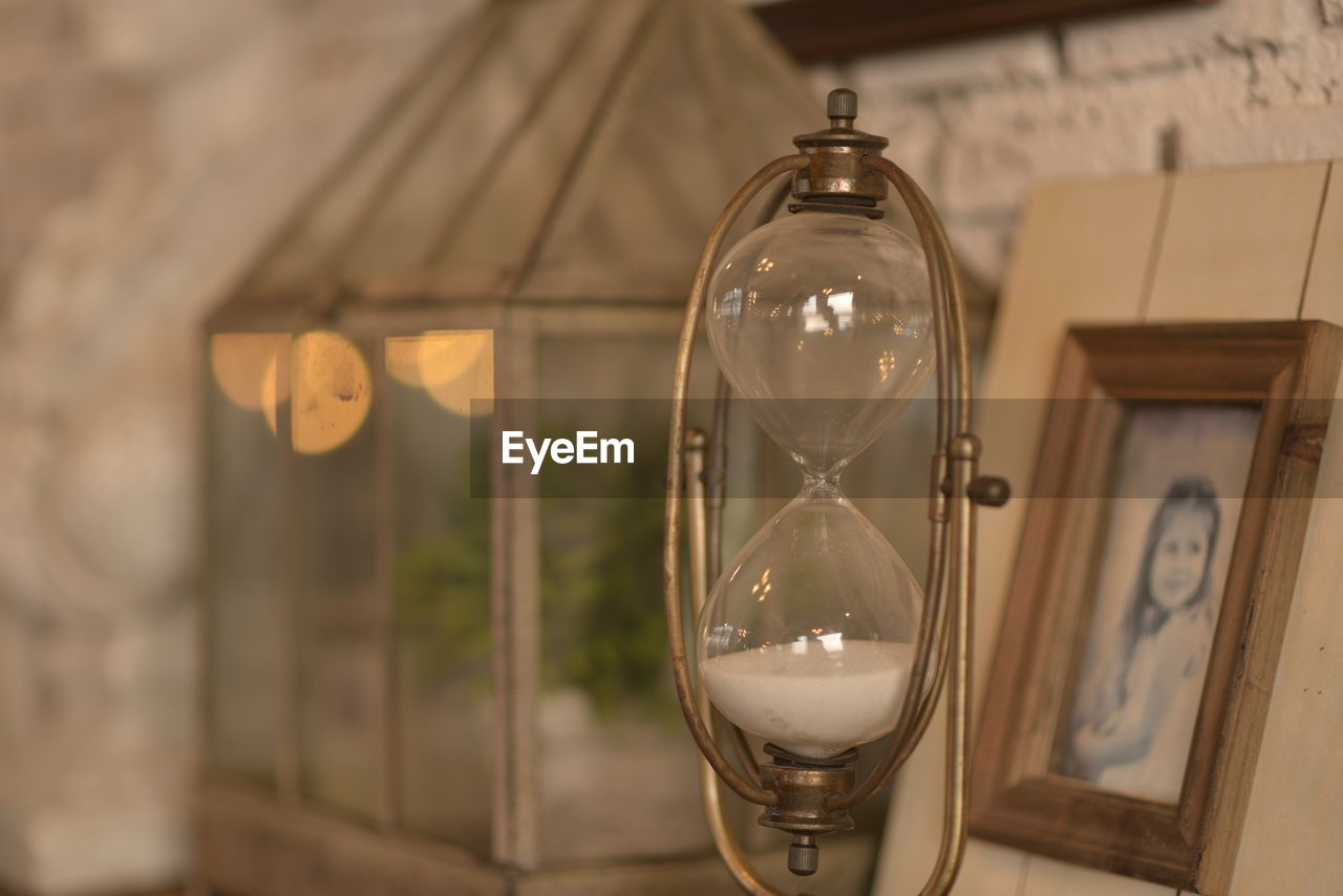 CLOSE-UP OF LIGHT BULB HANGING ON GLASS