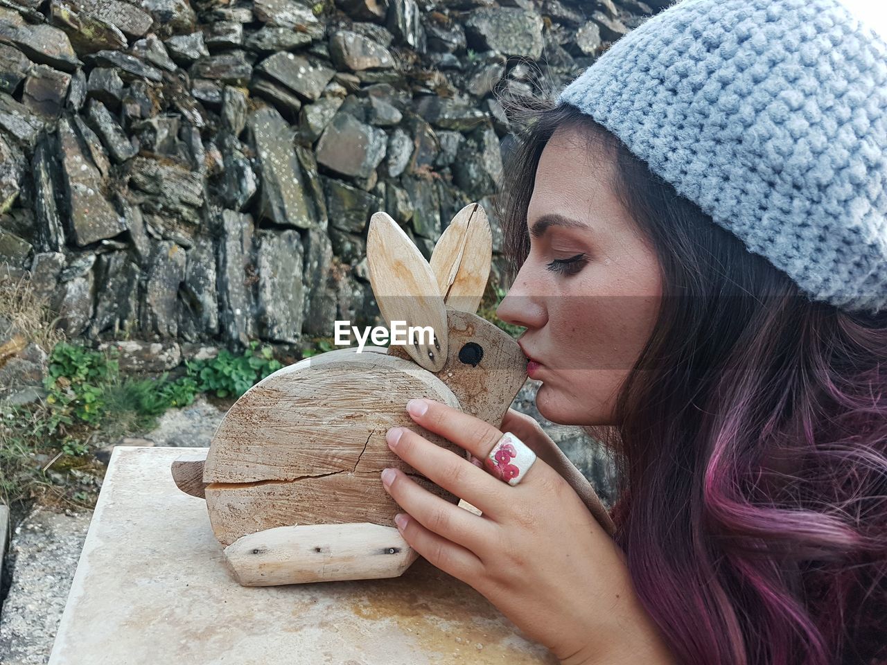 Woman kissing wooden rabbit toy