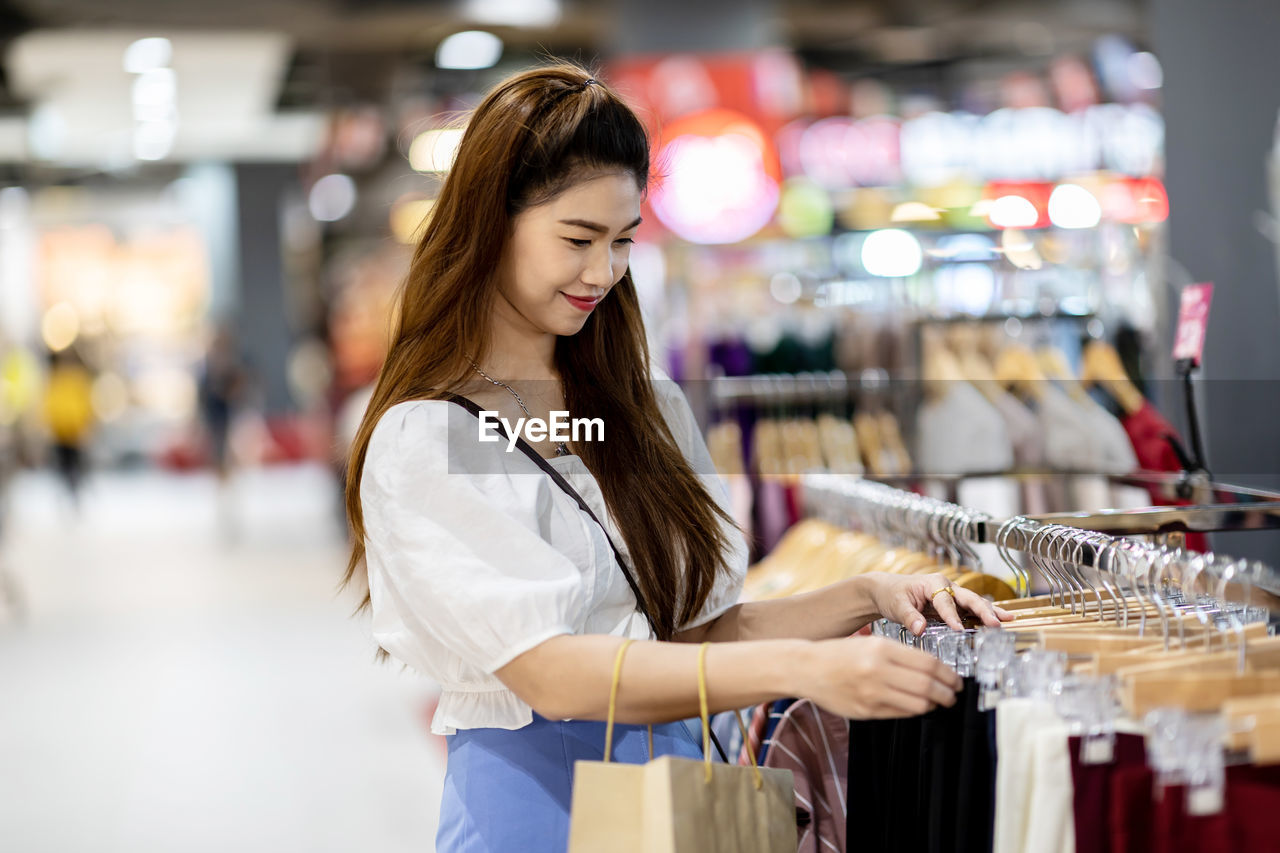 Smiling mid adult woman shopping in mall