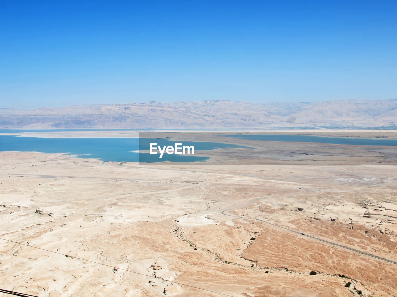 Scenic view of beach against clear blue sky