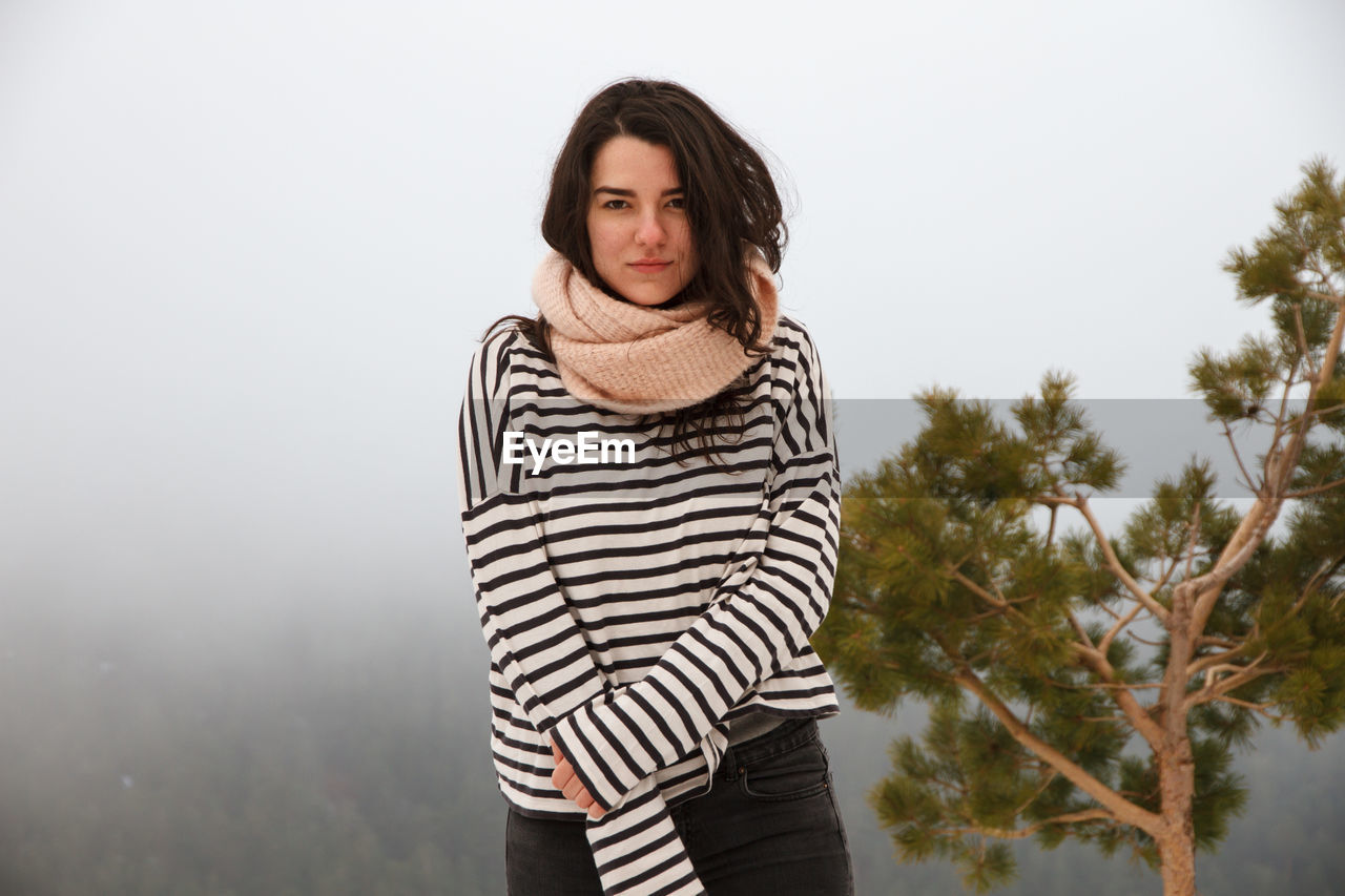 Portrait of young woman wearing striped top during foggy weather