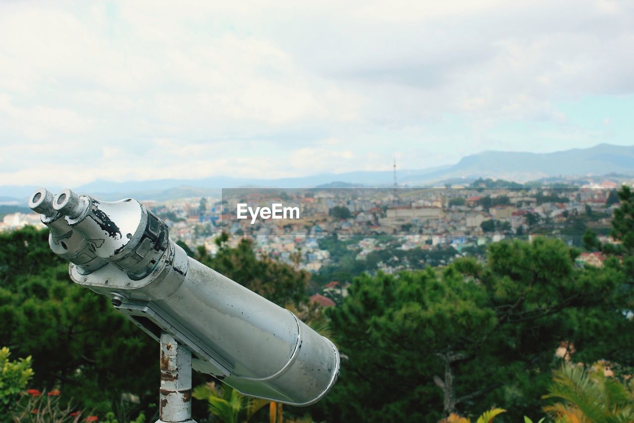 Binoculars at observation point against city