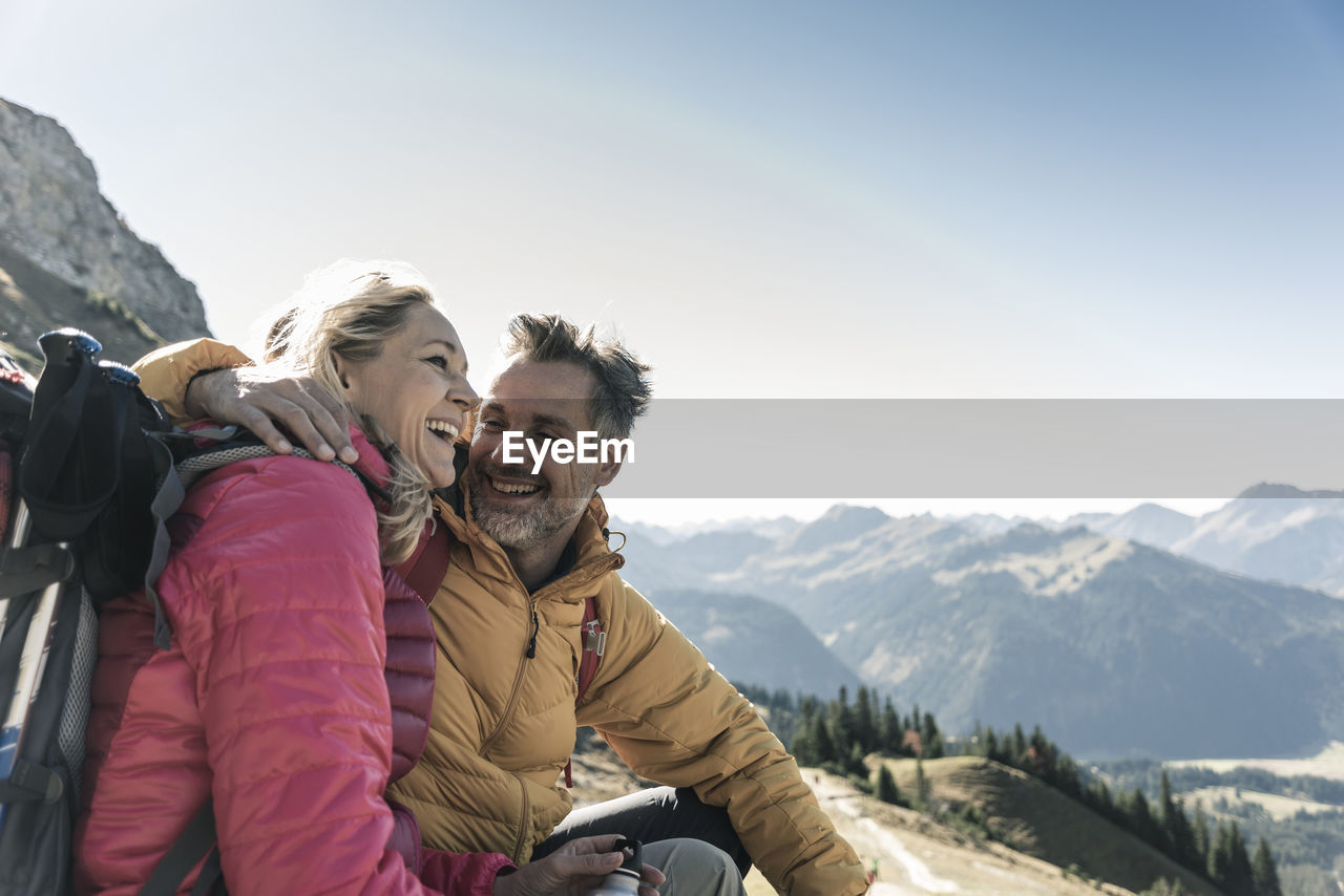 Austria, tyrol, happy couple having a break during a hiking trip in the mountains