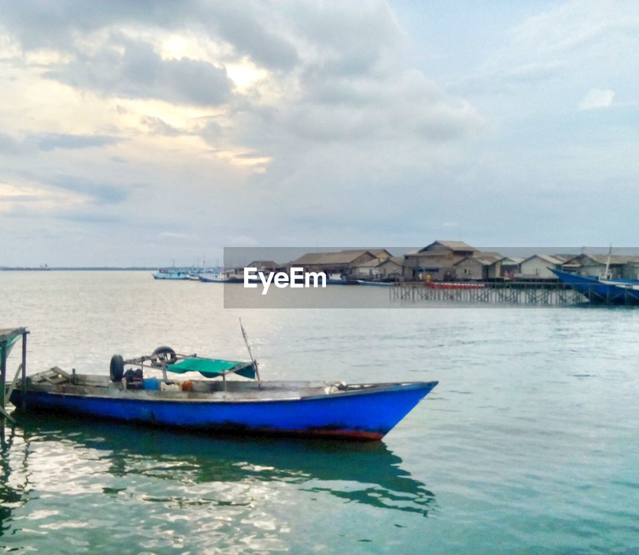 BOAT MOORED ON SEA AGAINST SKY