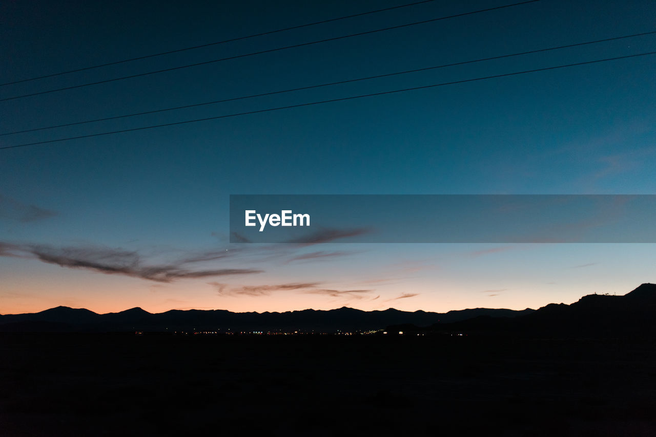 SCENIC VIEW OF SILHOUETTE MOUNTAIN AGAINST SKY AT SUNSET