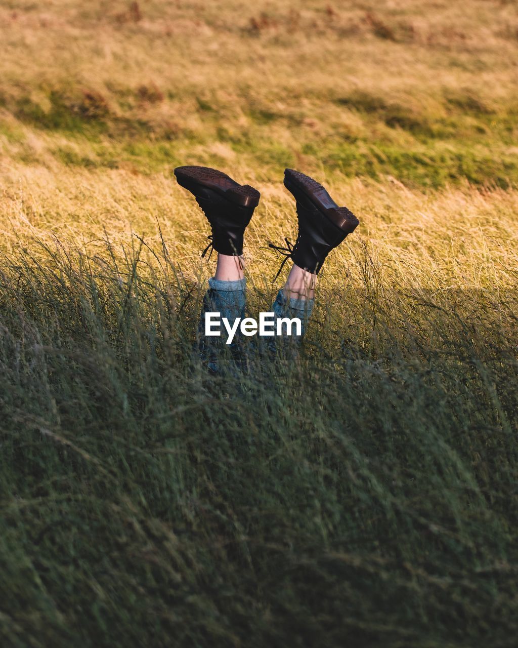 Low section of woman with feet up on field