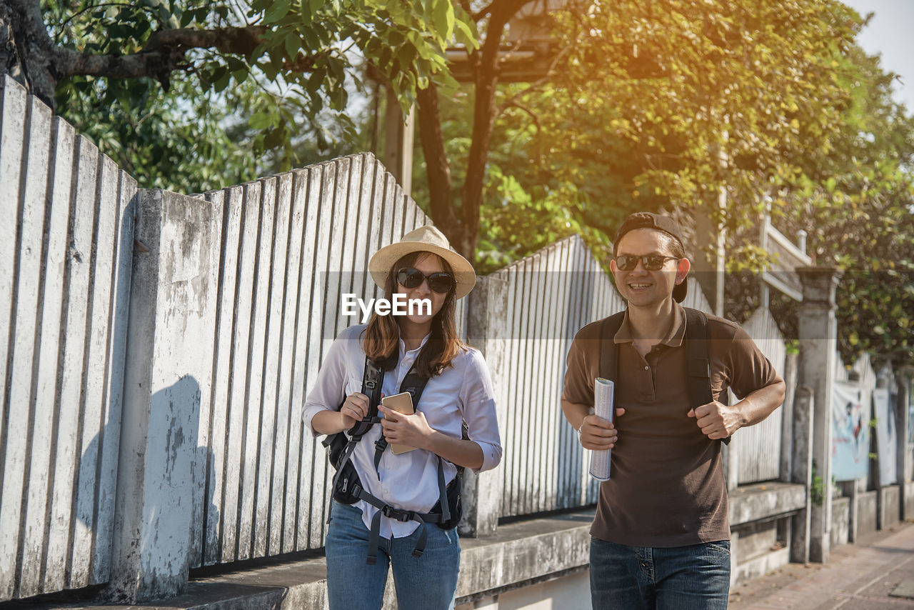 Smiling couple walking on footpath in city