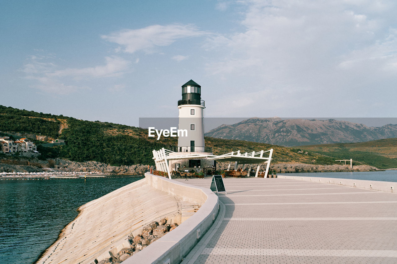 lighthouse by river against sky