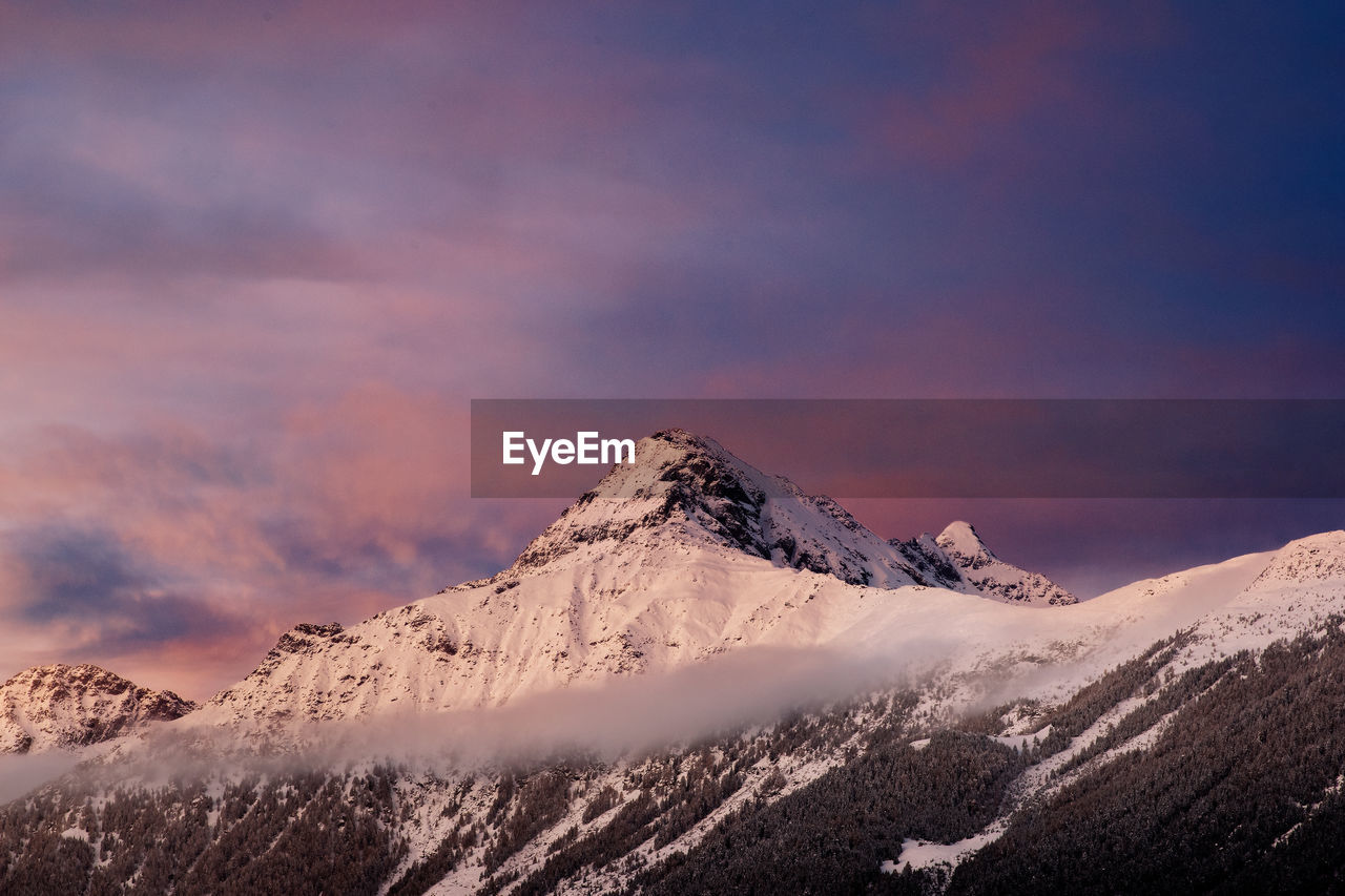 Scenic view of snowcapped mountains against sky during sunset