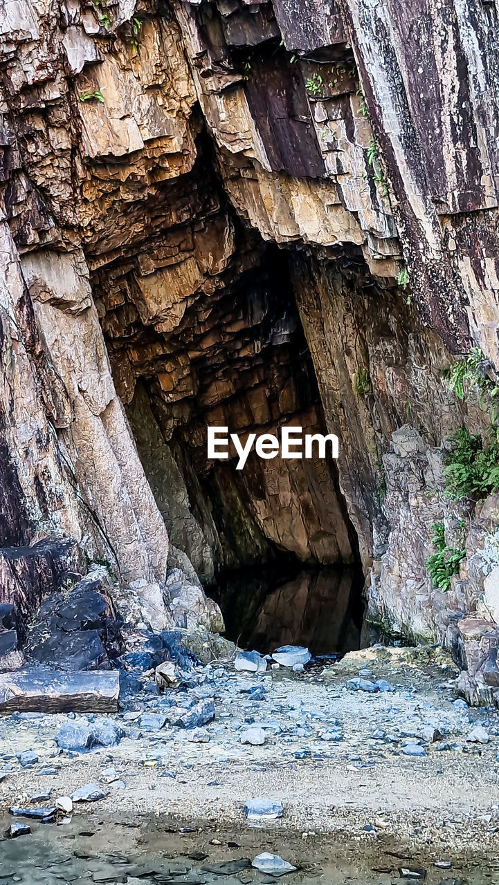 rock, water, no people, nature, rock formation, cliff, beauty in nature, day, cave, non-urban scene, geology, land, river, scenics - nature, outdoors, sea cave, formation, tranquility, terrain, wadi, environment, architecture, tree, eroded