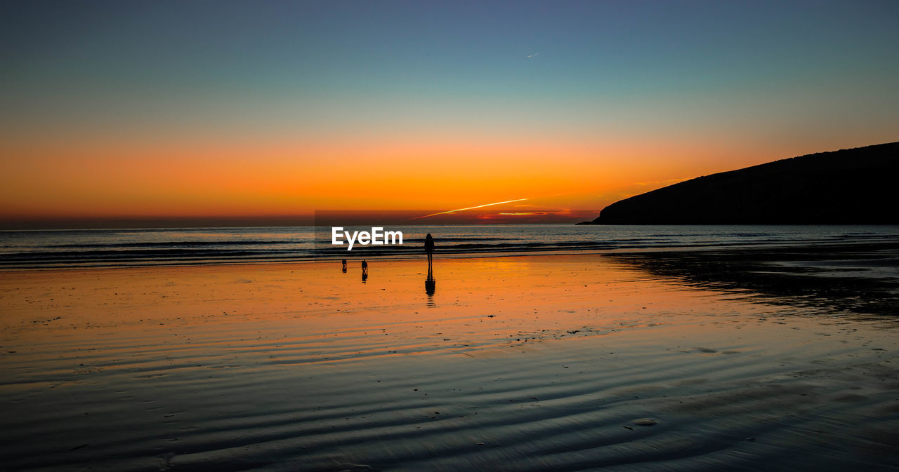 SCENIC VIEW OF BEACH AGAINST SKY AT SUNSET