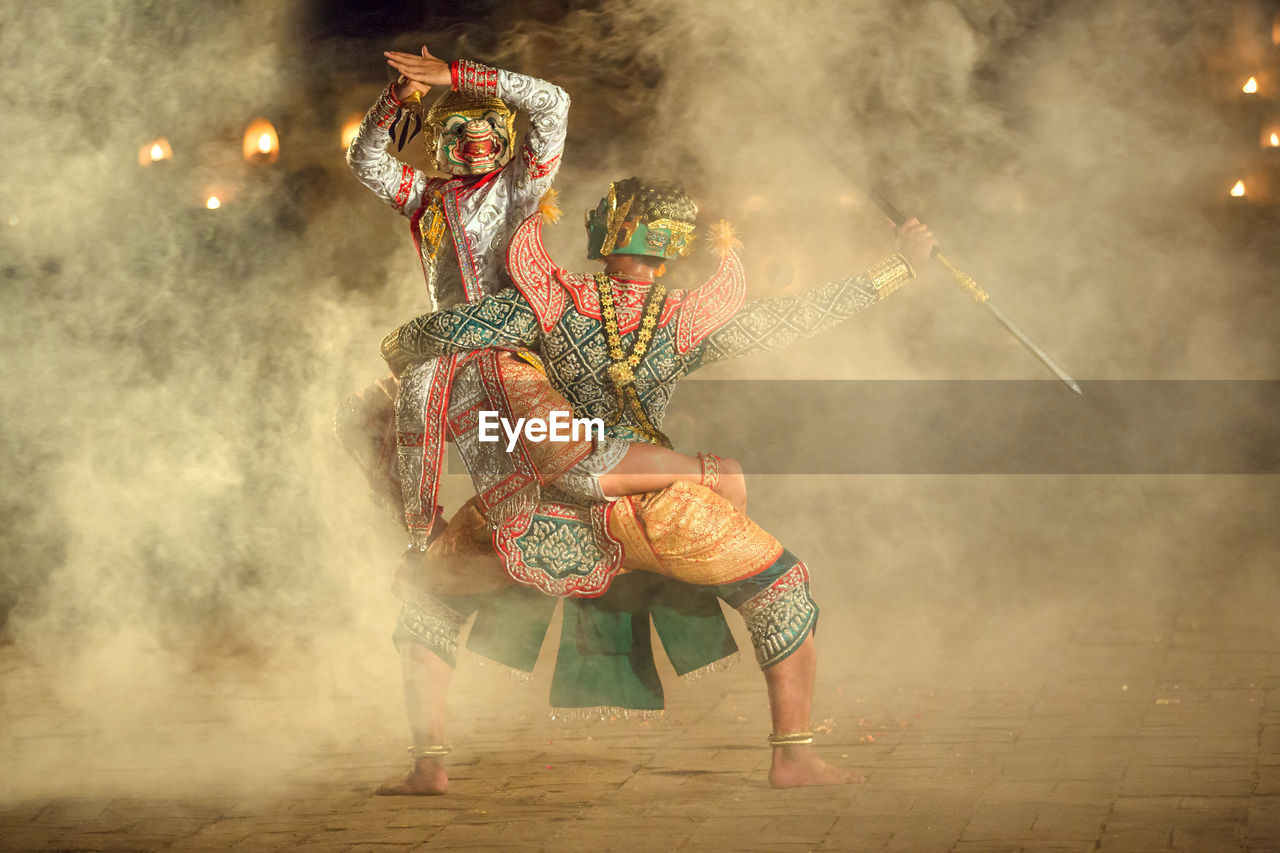 People dancing in traditional clothing at night