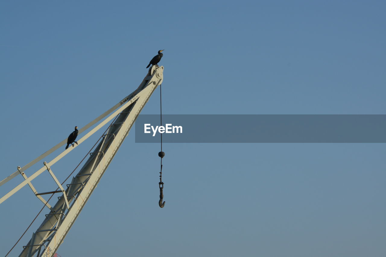 High section of crane against clear sky