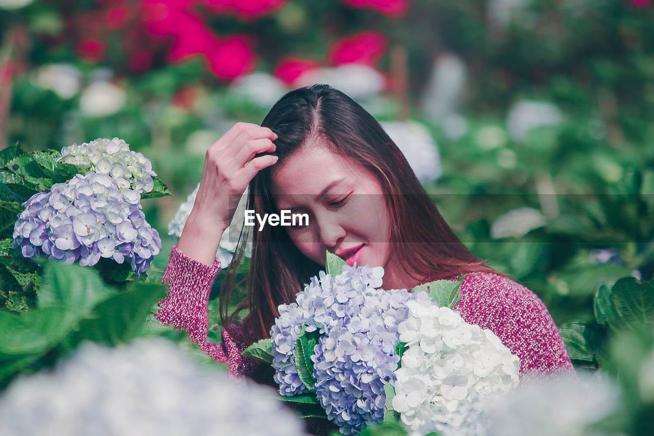 Smiling woman by flowering plants