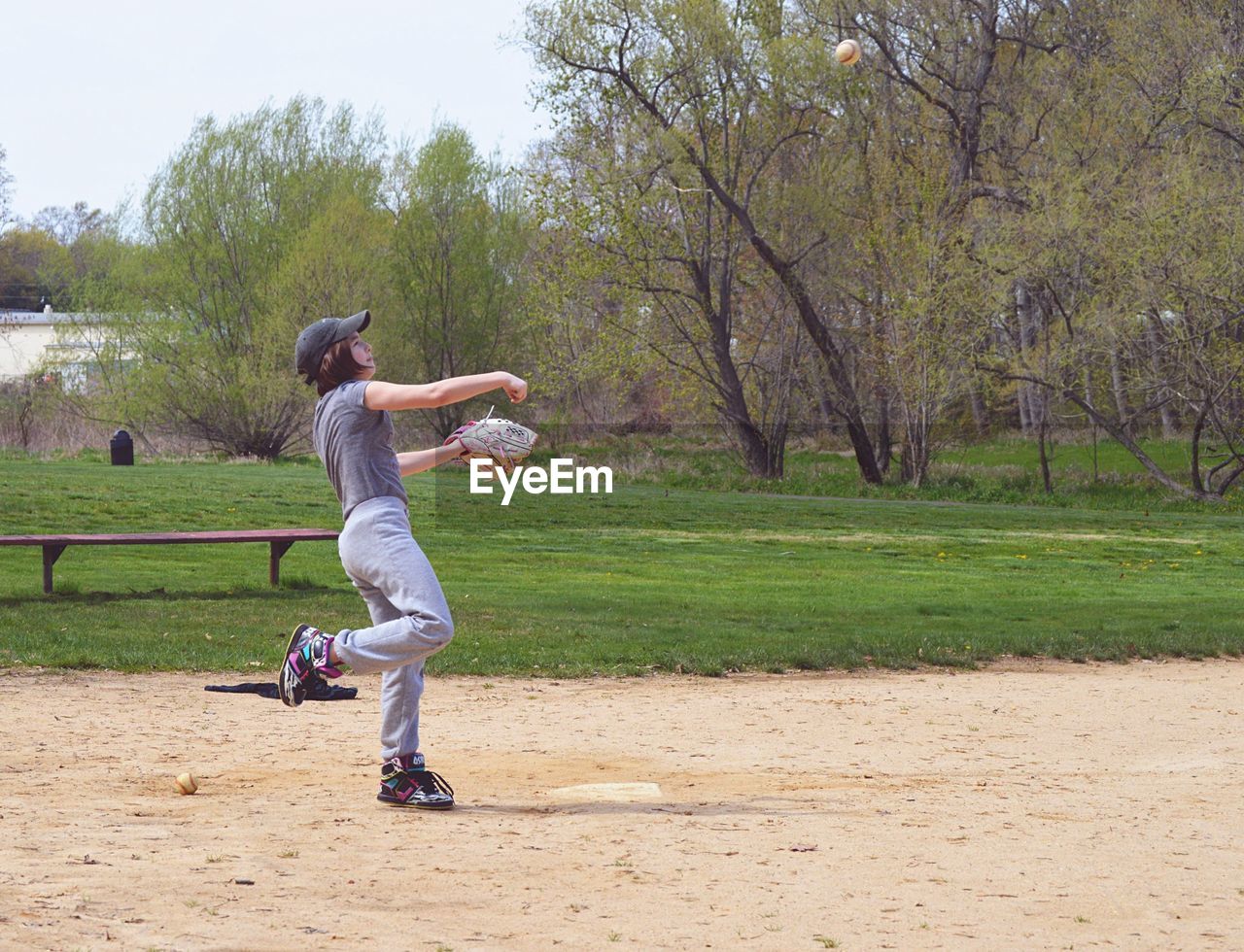 Teenage girl playing baseball in park