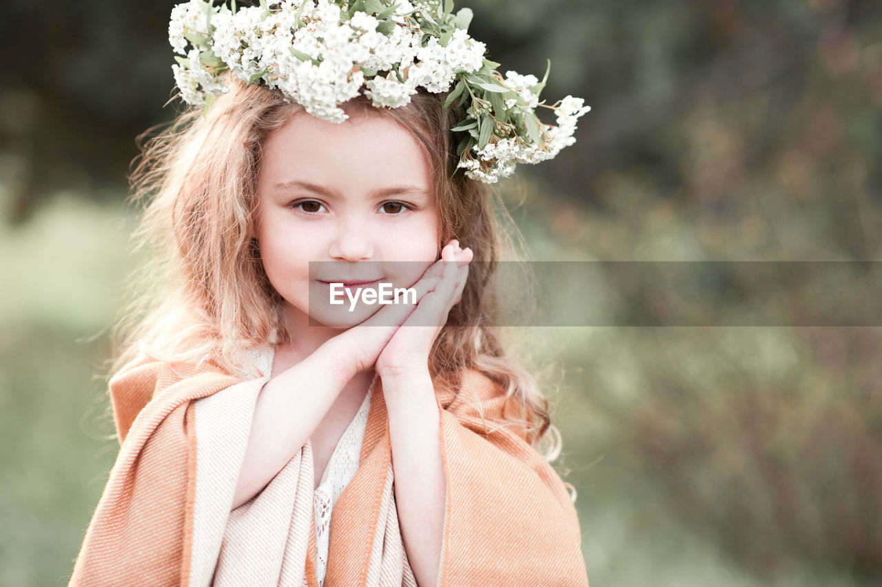 Portrait of girl wearing wreath at park