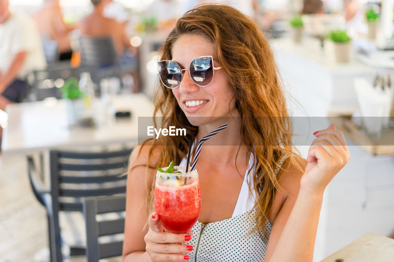 Woman holding juice in restaurant