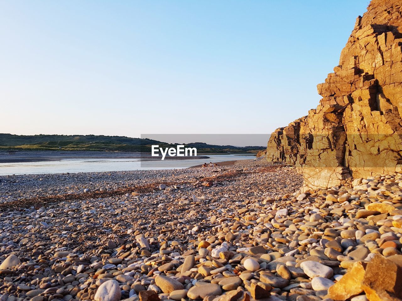 Rocks on beach against clear sky