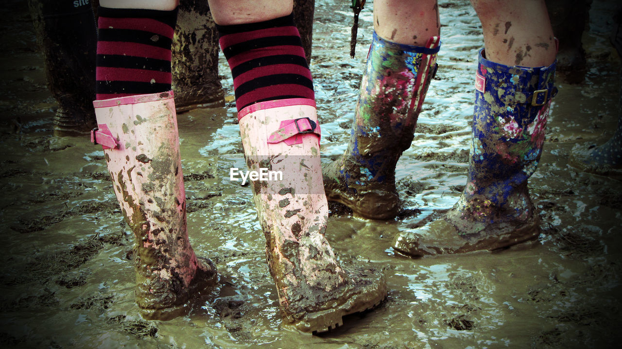 Low section of people standing in muddy puddle