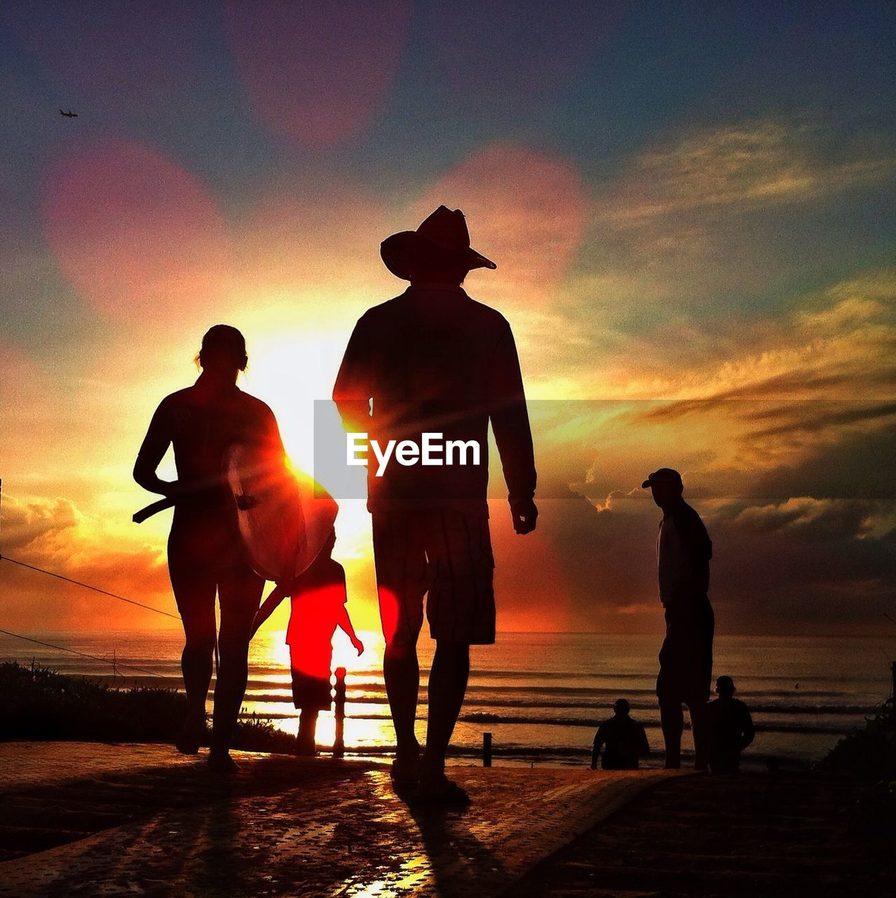 Silhouette people on beach at sunset