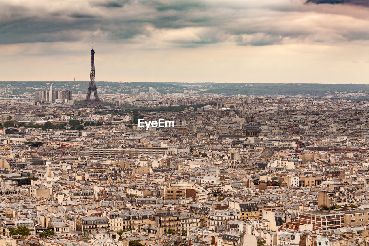 Aerial view of cityscape against cloudy sky
