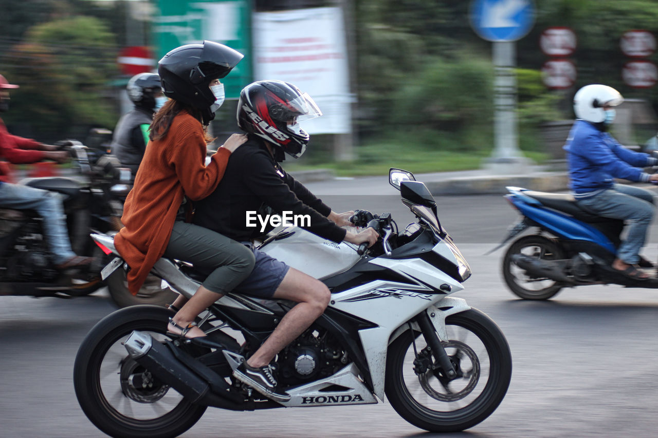 PEOPLE RIDING BICYCLES ON MOTORCYCLE