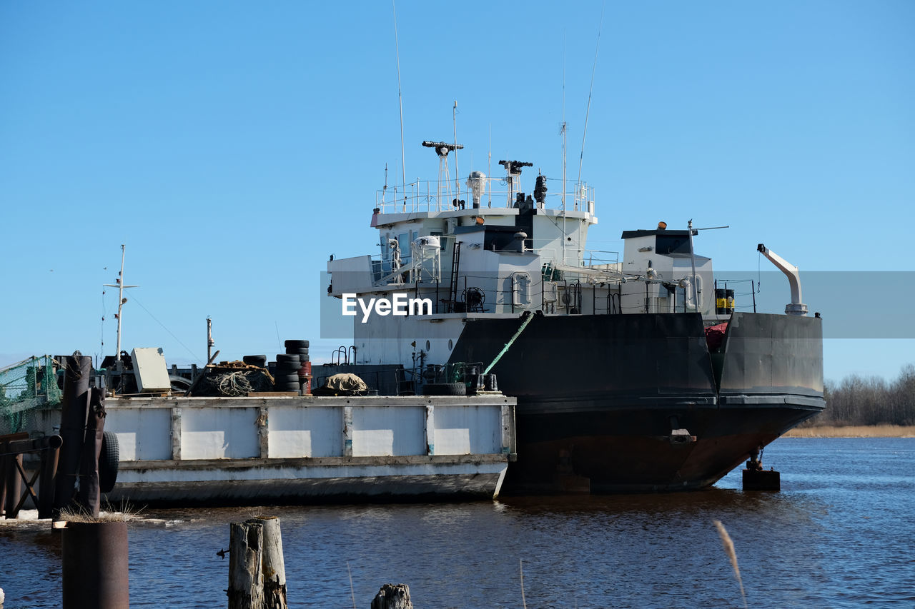 SHIP MOORED IN SEA AGAINST CLEAR SKY