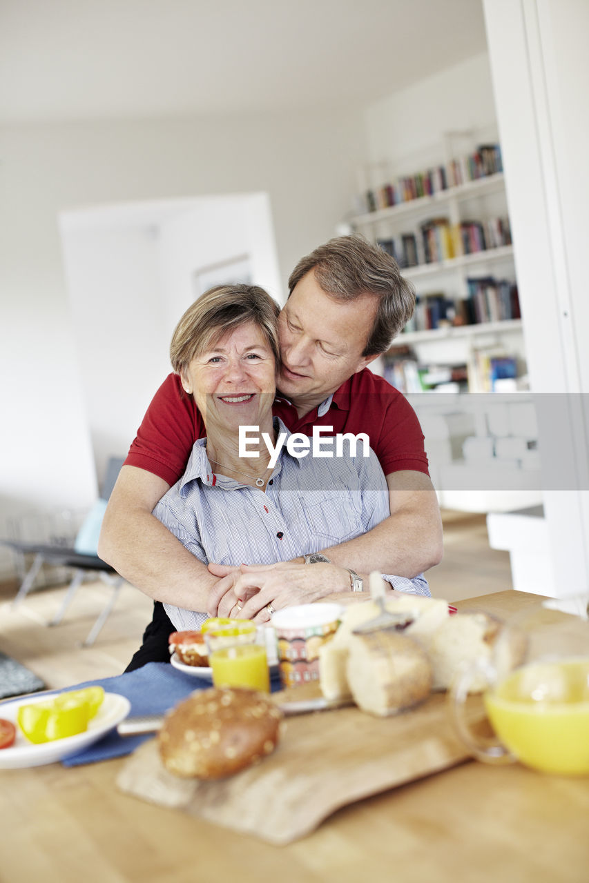 Mature couple embracing during breakfast